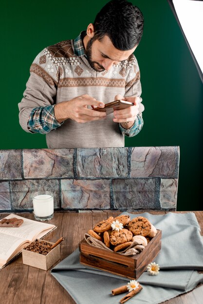 Man shooting cookie table with his smartphone