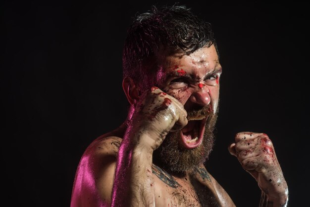 Man shout in fight position with blood on face, fists