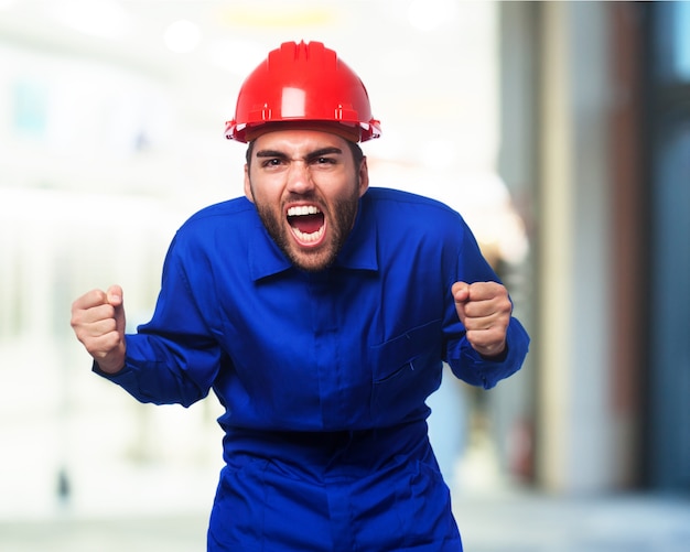 Man shouting with a blue work jumpsuit