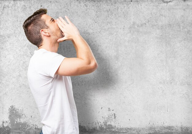 Man shouting with hands on face to one side