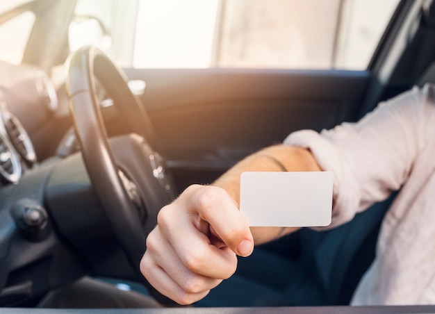 Man showing business card in car