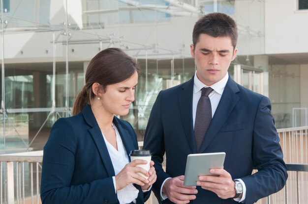 男は、タブレット、探している、コーヒーを保持している女性のデータを表示