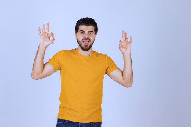 Man showing enjoyment and ok hand sign.