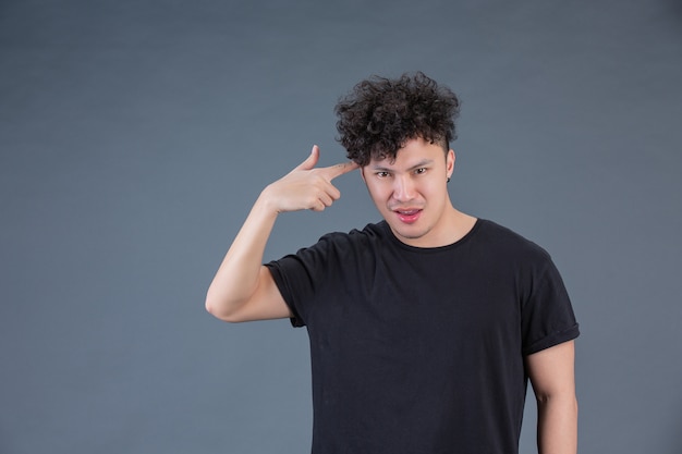 Free photo man showing hand gesture in studio behind posing