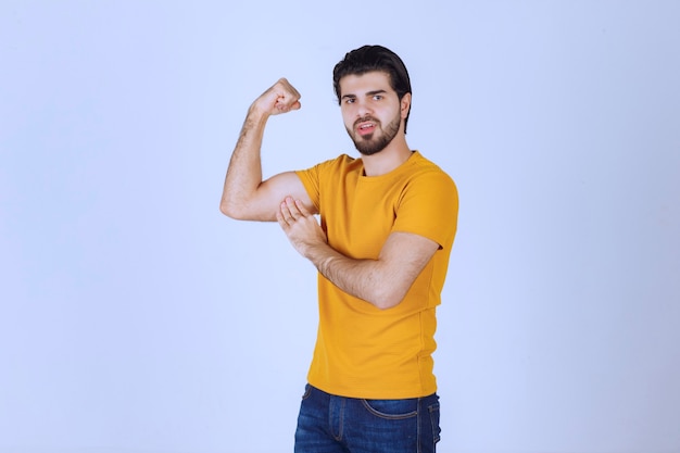 팔 근육을 보여주는 남자는 강력하다고 느낍니다.