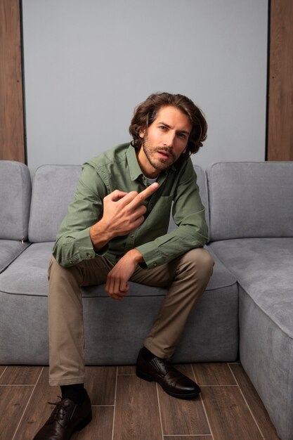 Man showing middle finger while sitting on the sofa