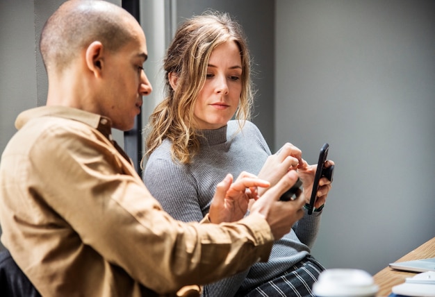 女性、スマートフォンに何かを見せる男