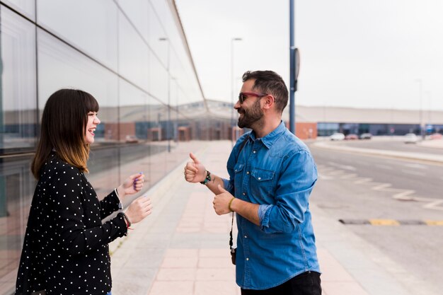 Man showing thumb up sign to her girlfriend