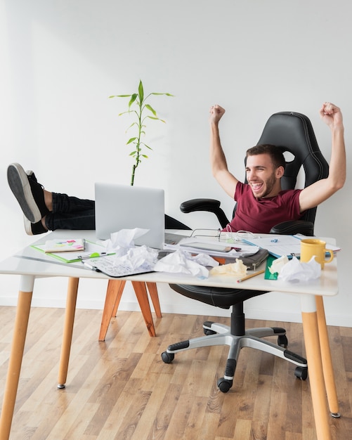 Man showing victory and sitting on a gaming chair