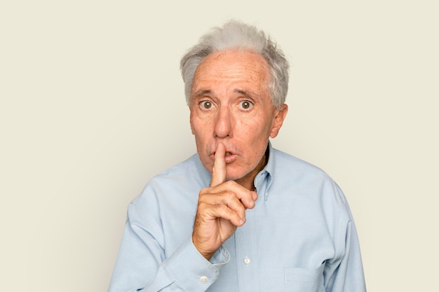 Man shushing gesture on beige background