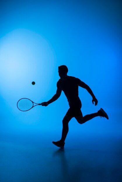 Man silhouette playing tennis full shot