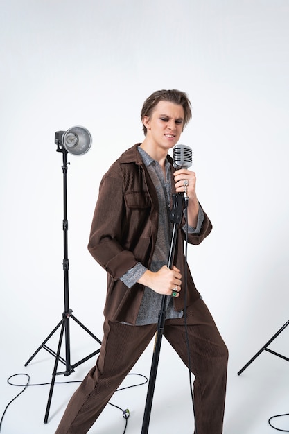 Free photo man singing with microphone full shot