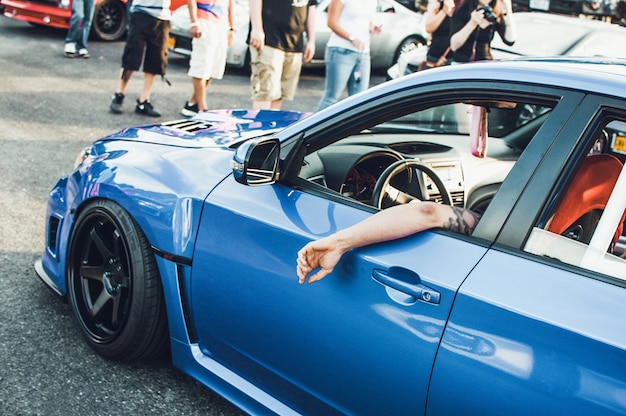 Free photo man sits in blue bmw on the street