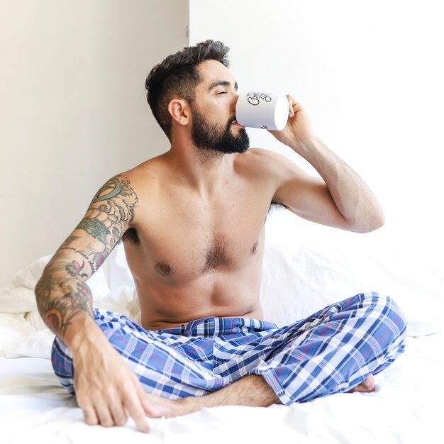 Man sitting on bed drinking coffee