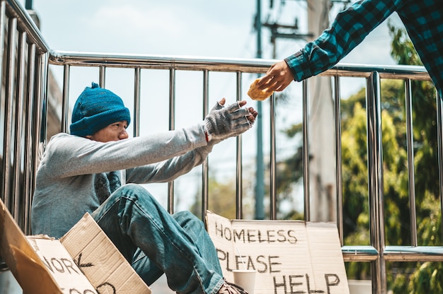 Free photo the man sitting begging on an overpass.