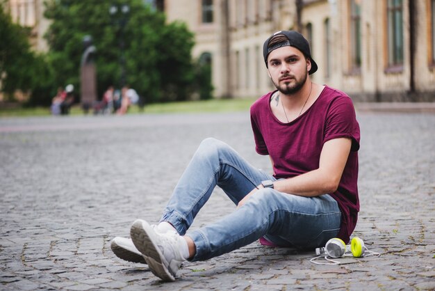 Man sitting on block stone posing