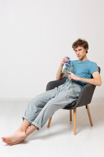 Man sitting in chair and holding flowers