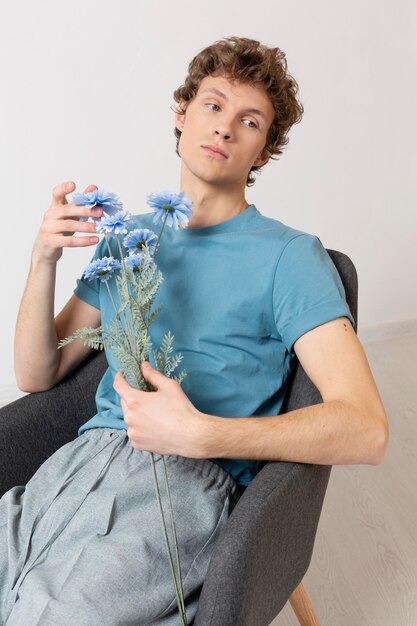 Man sitting in chair and holding flowers