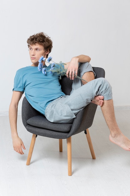 Man sitting in chair and holding flowers