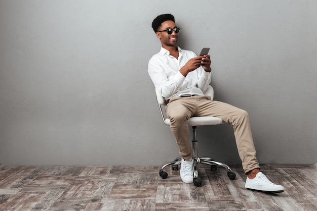 Man sitting in a chair and holding mobile phone