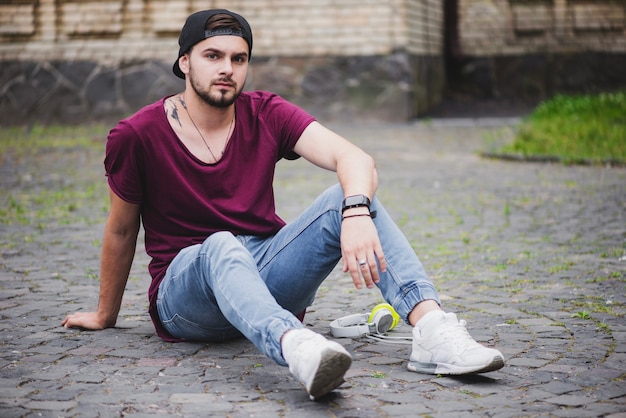 Man sitting on cobblestone road