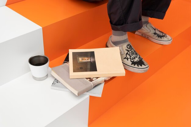 Man sitting at the coffeehouse next to books and coffee cup