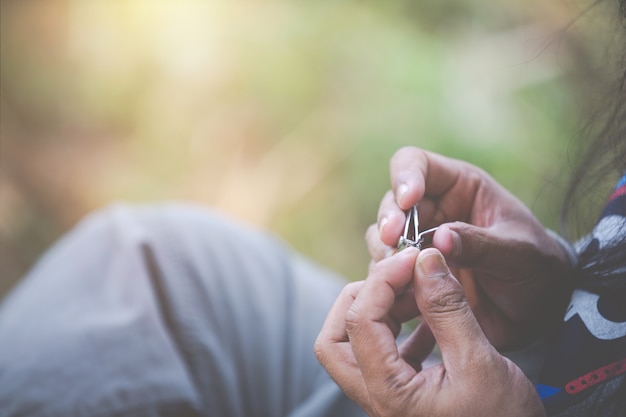 Man sitting to cut nails.