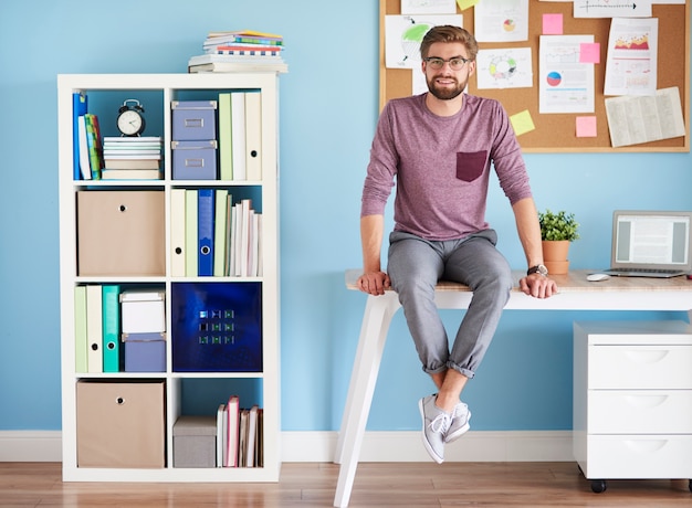 Man sitting on desk in the home office