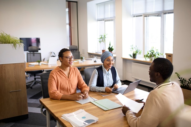 Man sitting down for an office job interview at desk with his employers