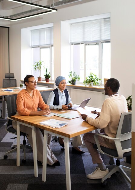 Man sitting down for an office job interview at desk with his employers