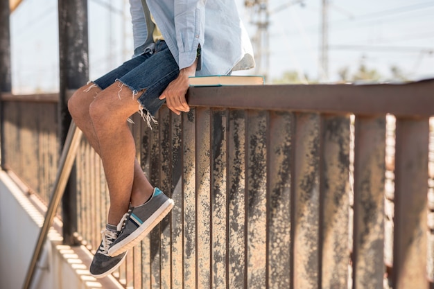 Man sitting on fence waiting for train