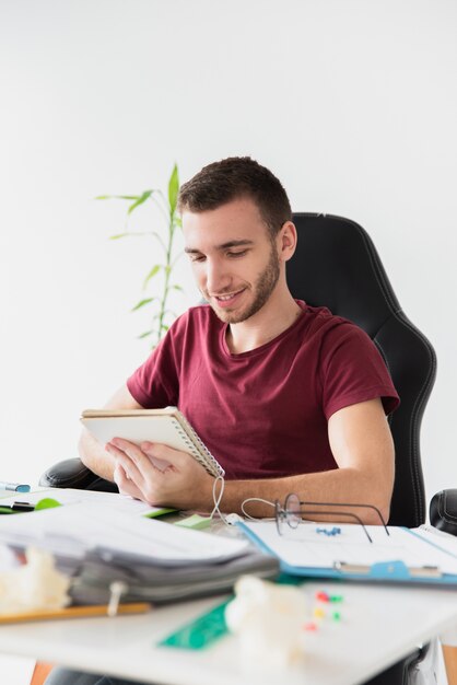 Man sitting on a gaming chair looking at his notes