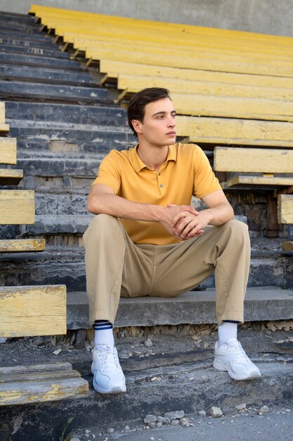 Free photo man sitting in grandstands full shot