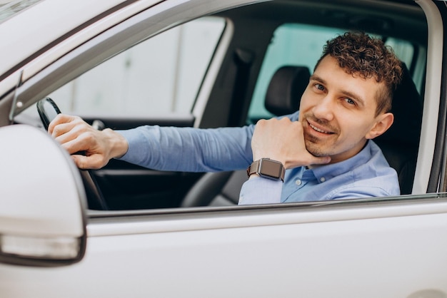 Man sitting in his car and looking through the window