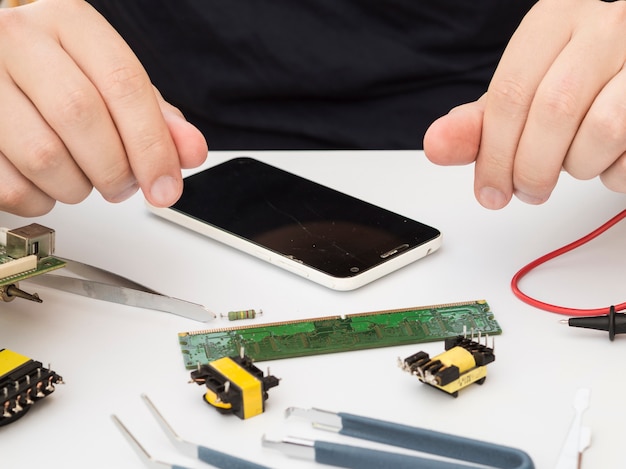 Foto gratuita uomo seduto al suo tavolo di lavoro con elettronica