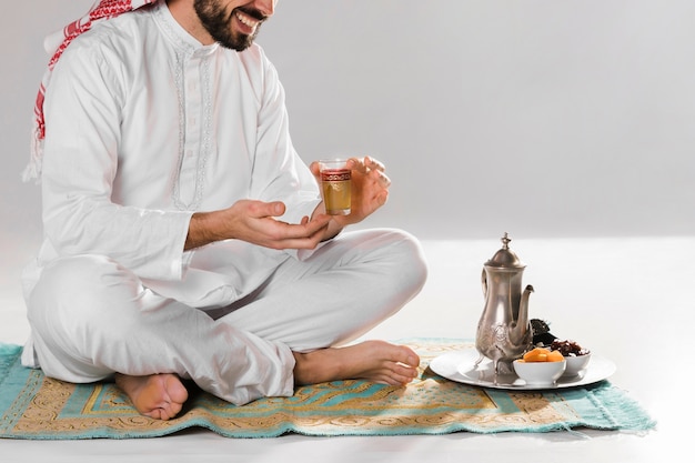 Man sitting and holding arabic cup of tea