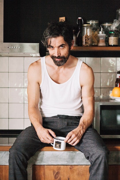 Free photo man sitting on kitchen table