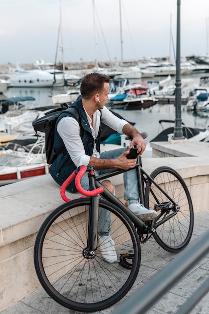 自転車の横に座って目をそらしている男