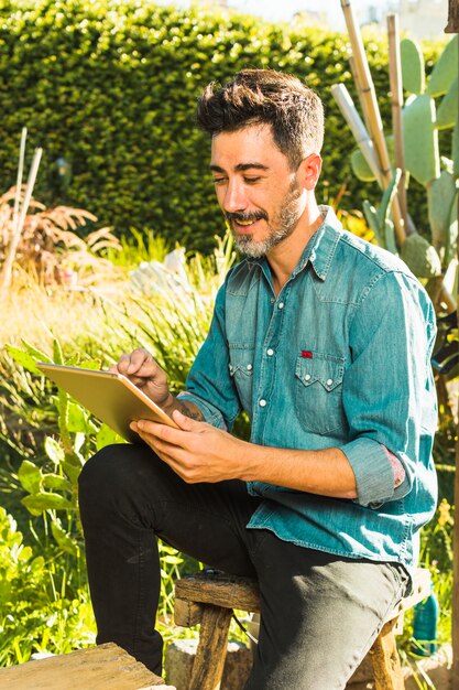 Man sitting outdoor in the park using digital tablet