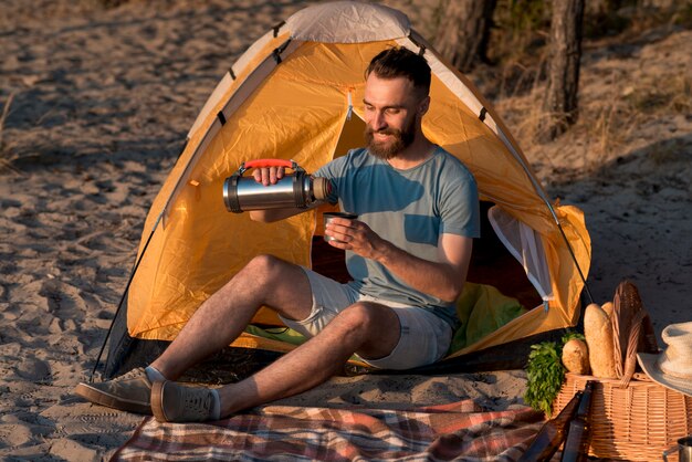 Man sitting and pouring from thermos