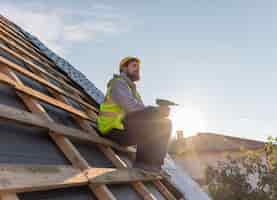 Free photo man sitting on the roof