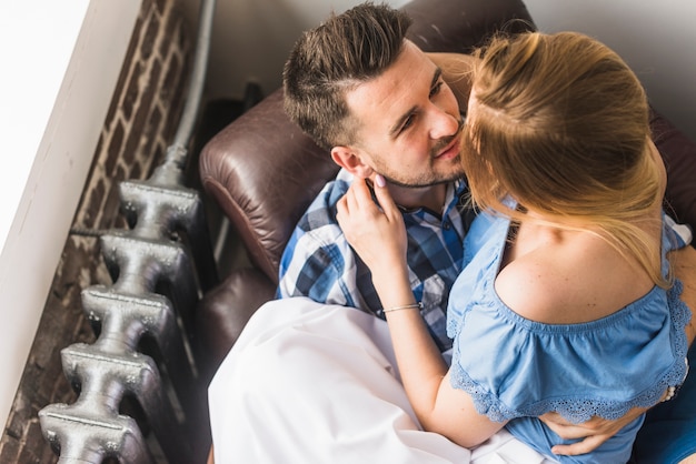 Uomo seduto sul divano con la sua ragazza