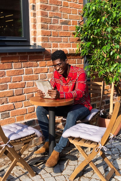Foto gratuita uomo seduto a un tavolo e leggere