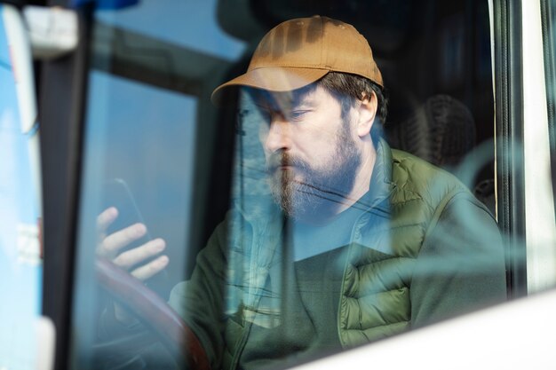 Man sitting in truck with phone side view