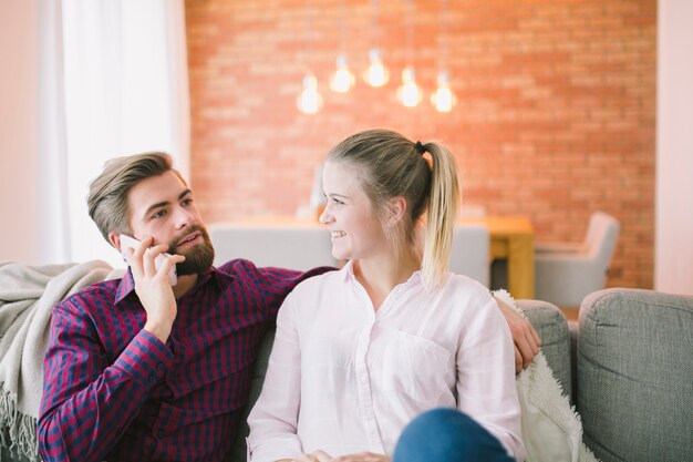 Man sitting with girlfriend and talking phone