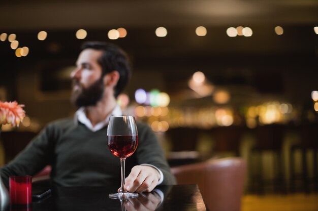 ワインのグラスで座っている男
