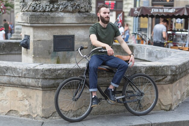 Человек, сидящий со своим велосипедом