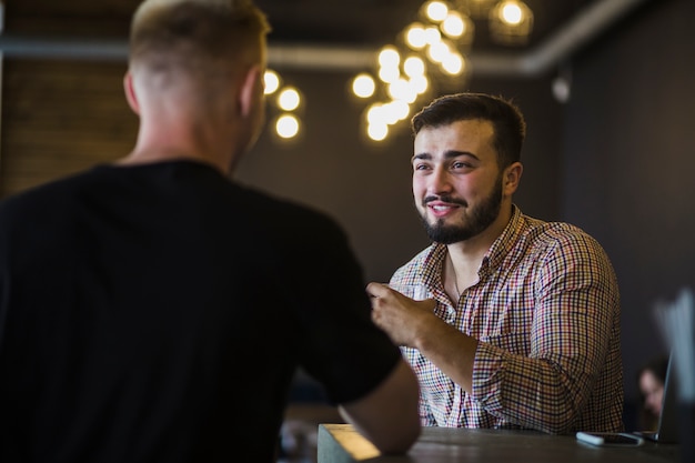 Man sitting with his friend enjoying drinks in the restaurant