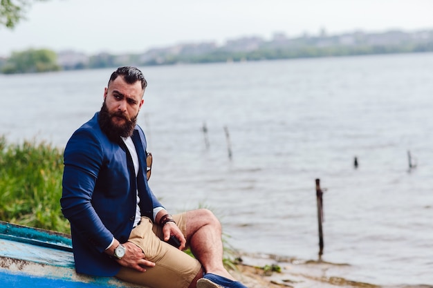 Man sitting with one hand in his pocket outdoors