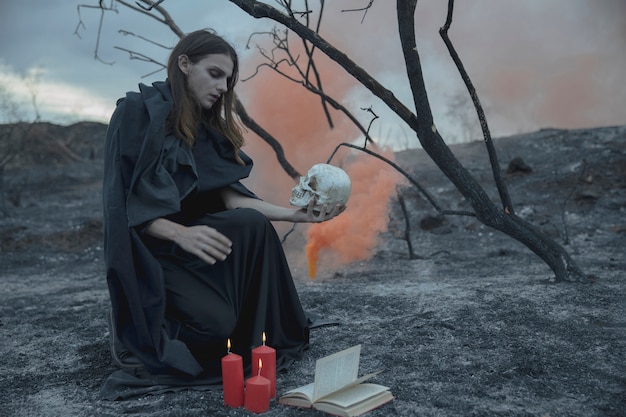 Man sitting with a skull in his hand and looking at it